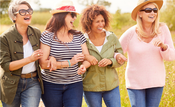 Four ladies laughing and walking in the open air 